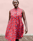 model wearing a sleeveless dress with a red, blue, white and black design