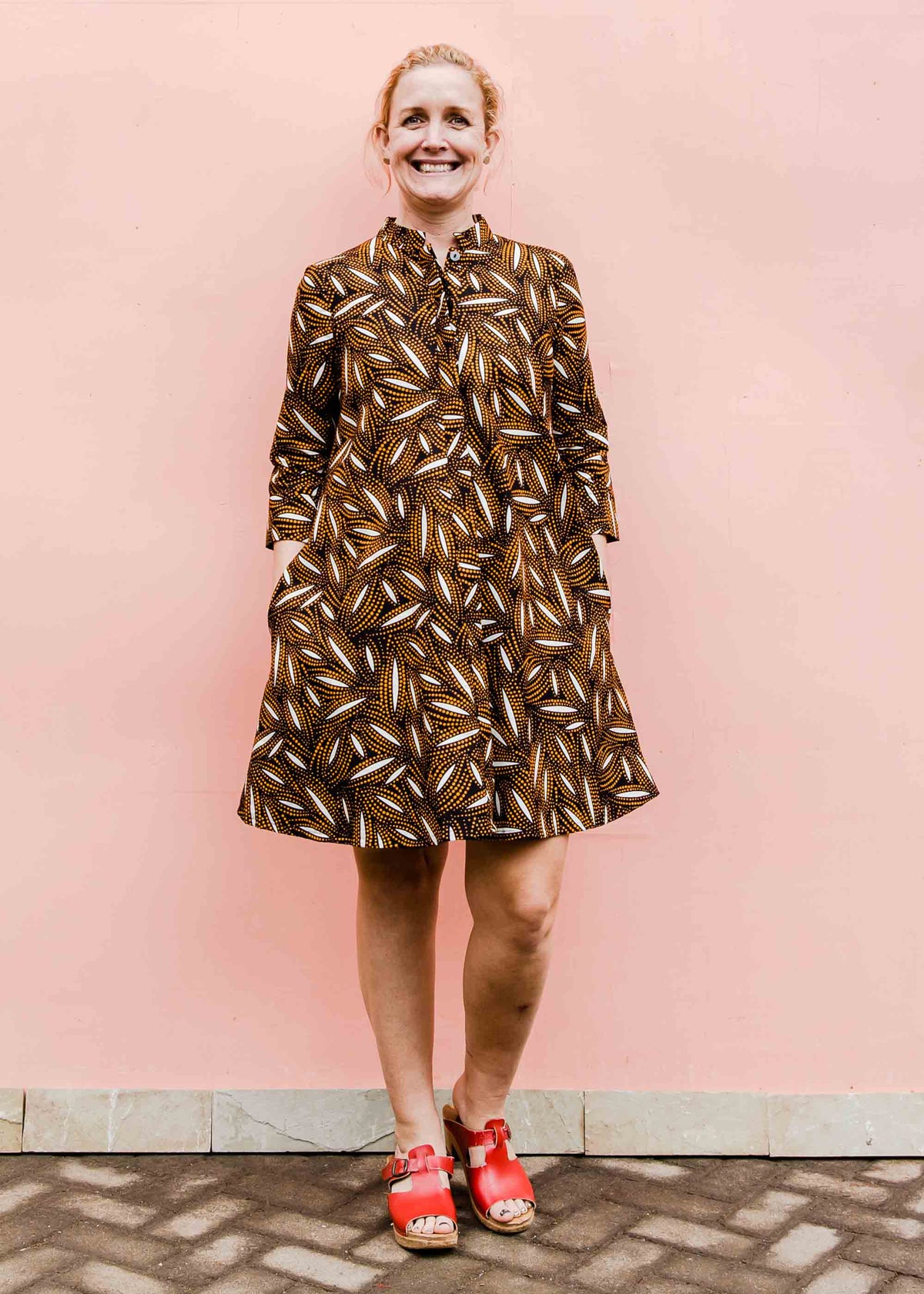 model wearing a brown, black and white seed design dress