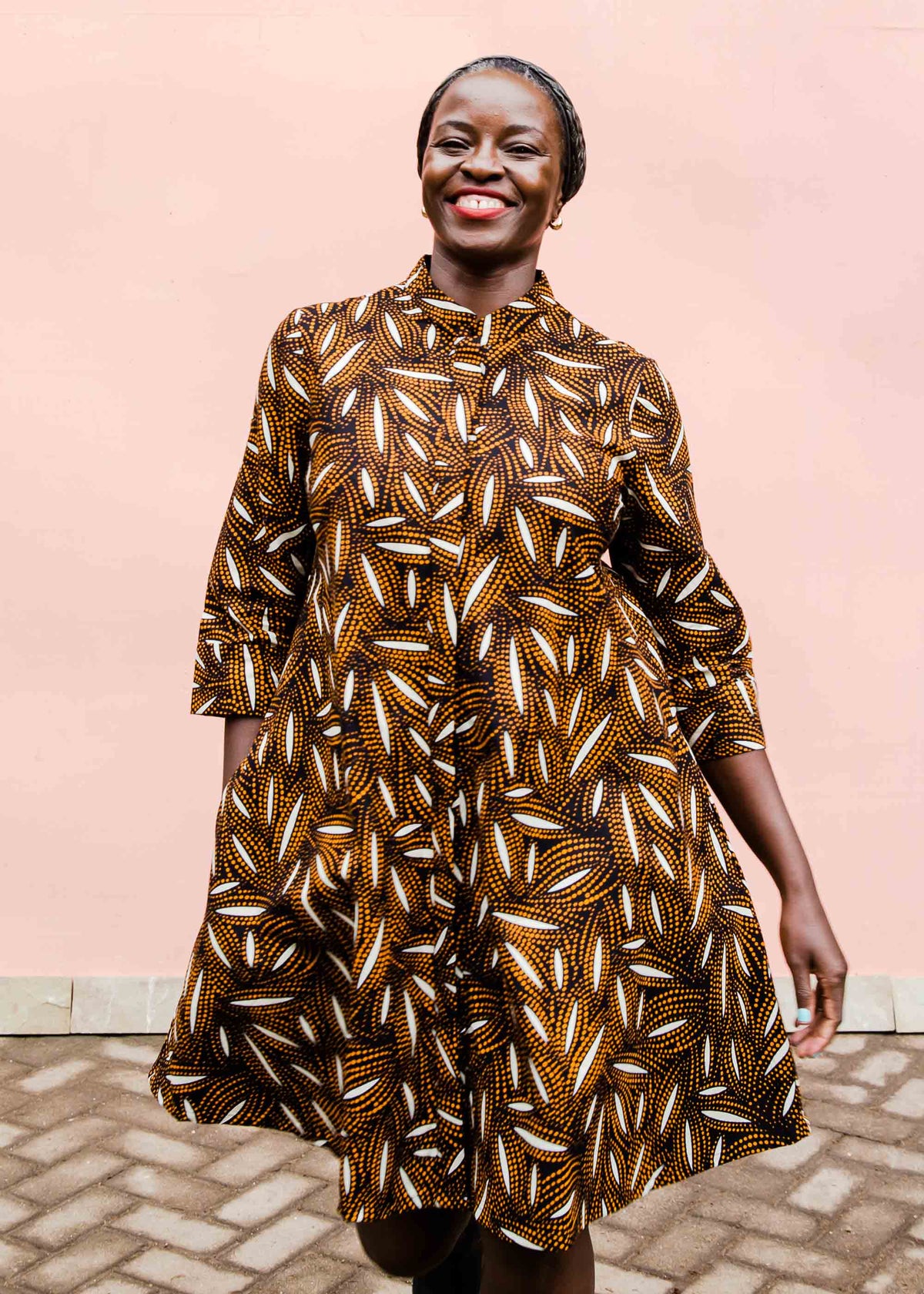 model wearing a brown, black and white seed design dress