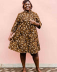model wearing a brown, black and white seed design dress