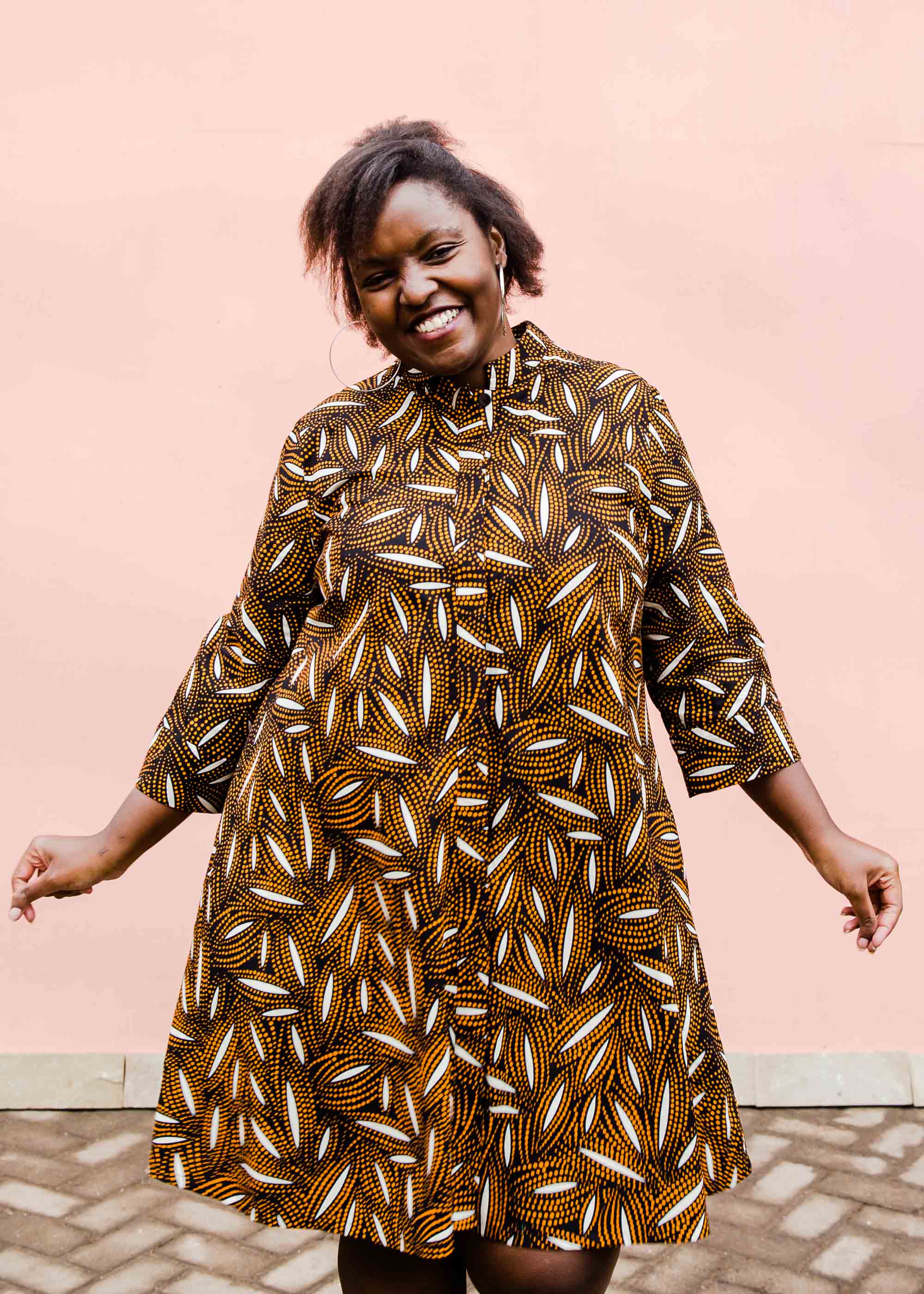 model wearing a brown, black and white seed design dress