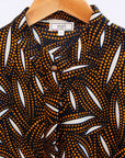 Display of a brown, black and white seed design dress