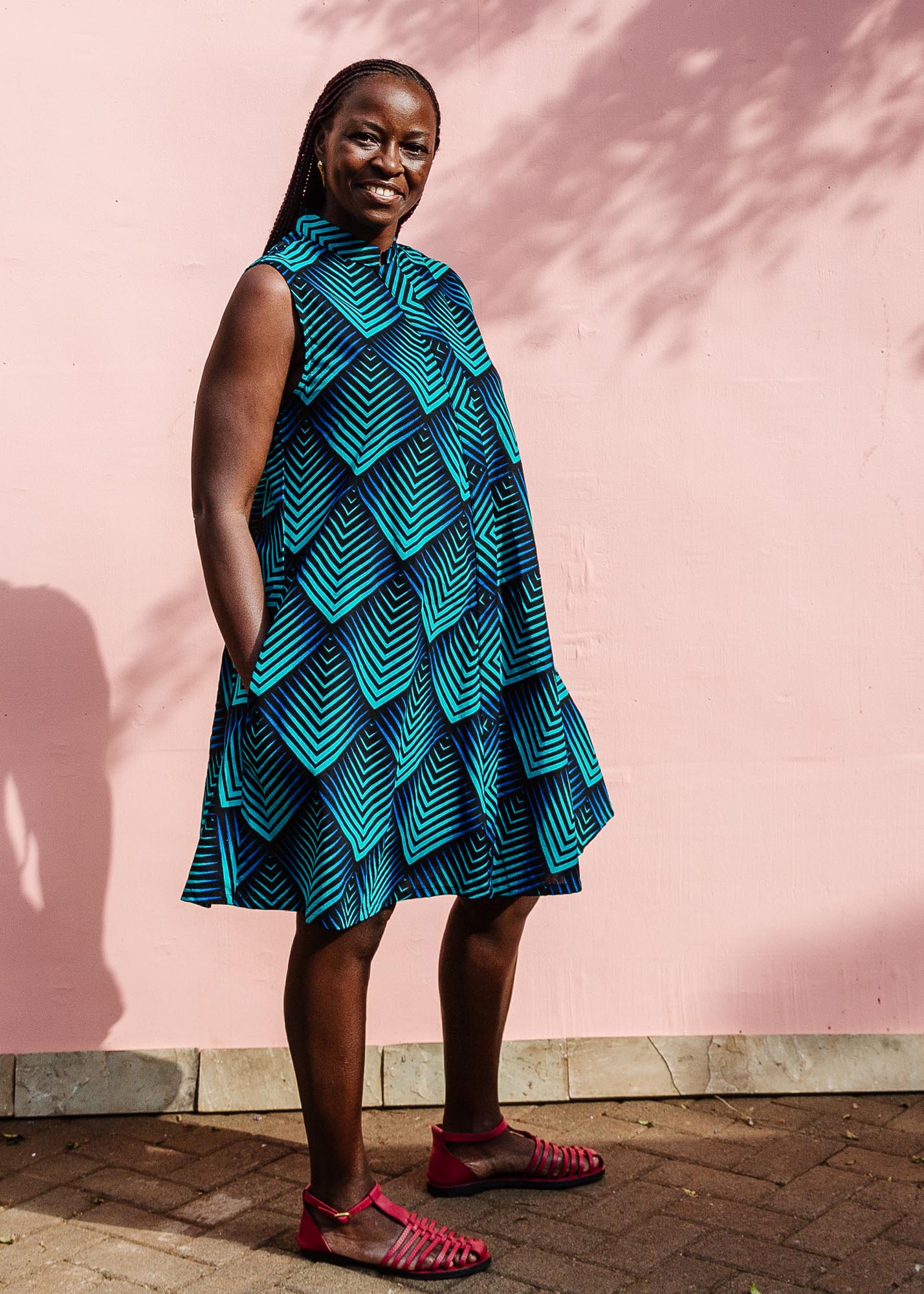 Model wearing blue and black geometric print sleeveless dress