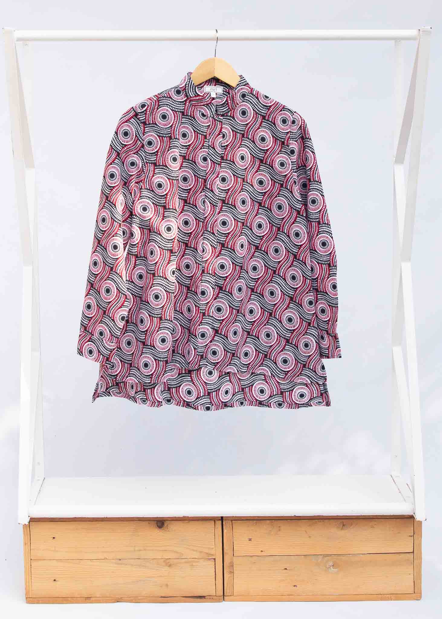 Display of long sleeve blouse with black, red, and white circles.