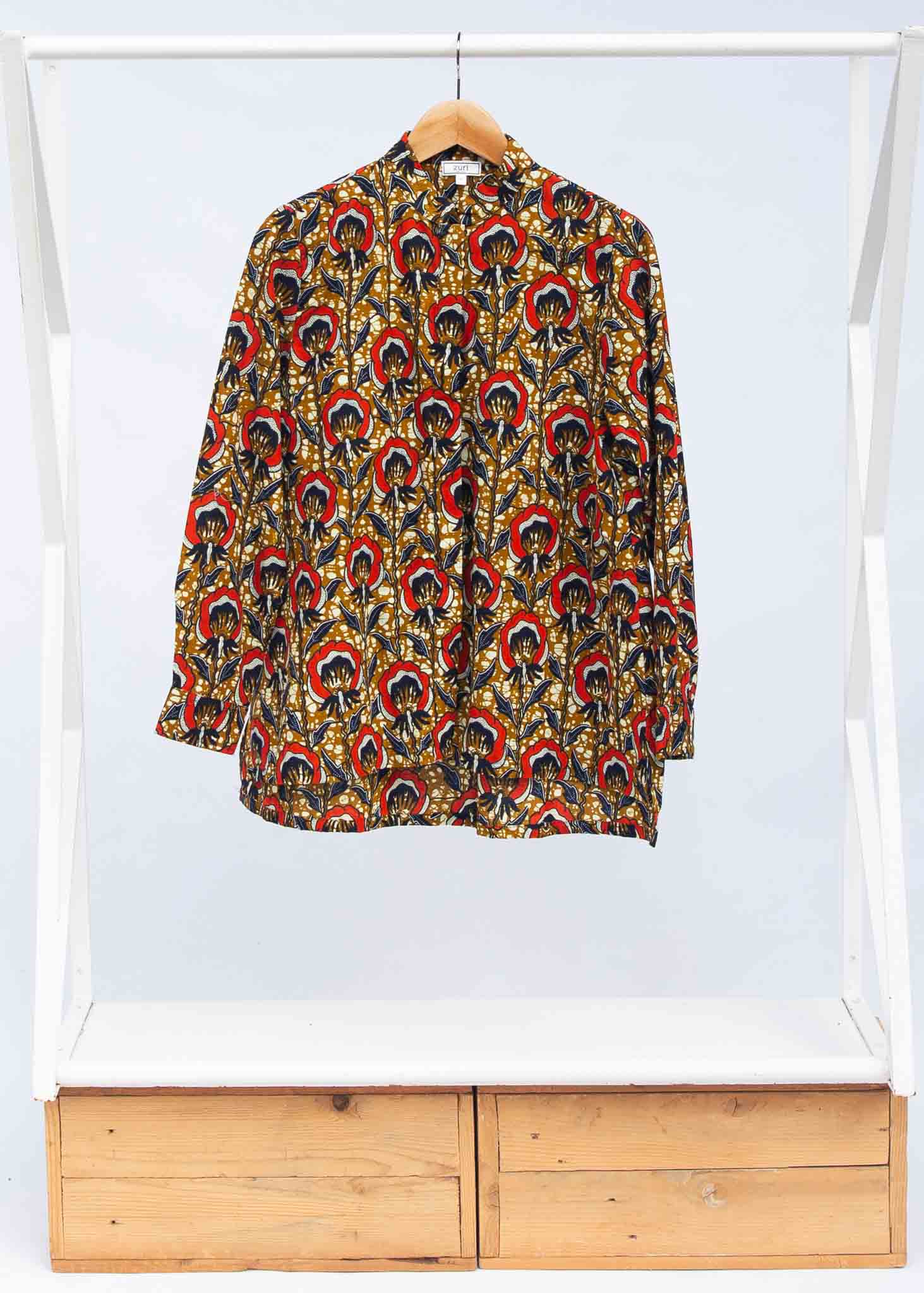 Display of mustard long sleeve blouse with red floral print.