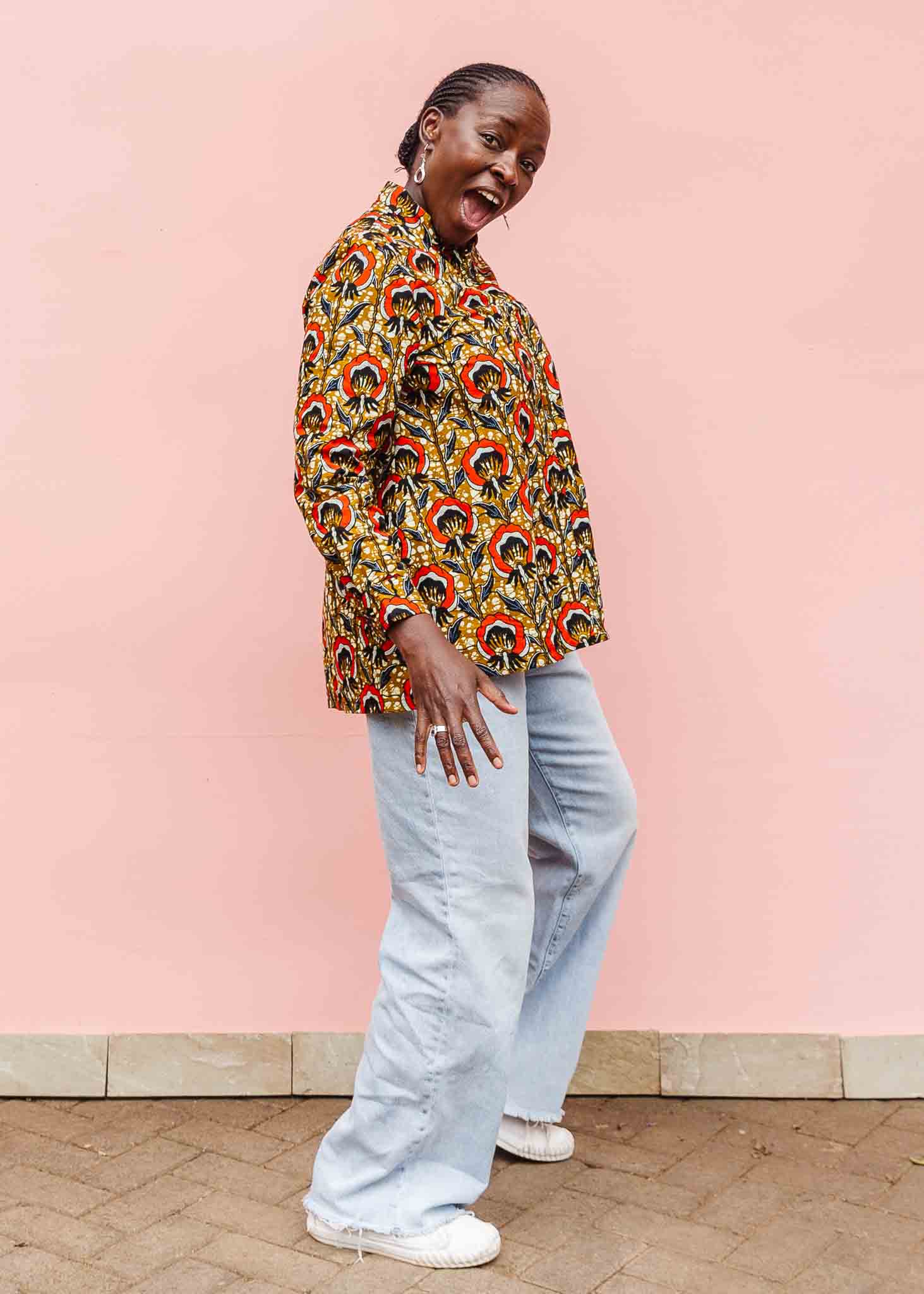 Model wearing mustard long sleeve blouse with red floral print.