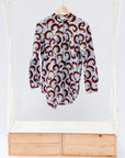 White shirt with red vines and tendrils
