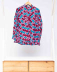 Display of pink, red, blue and black tube print long sleeve blouse.