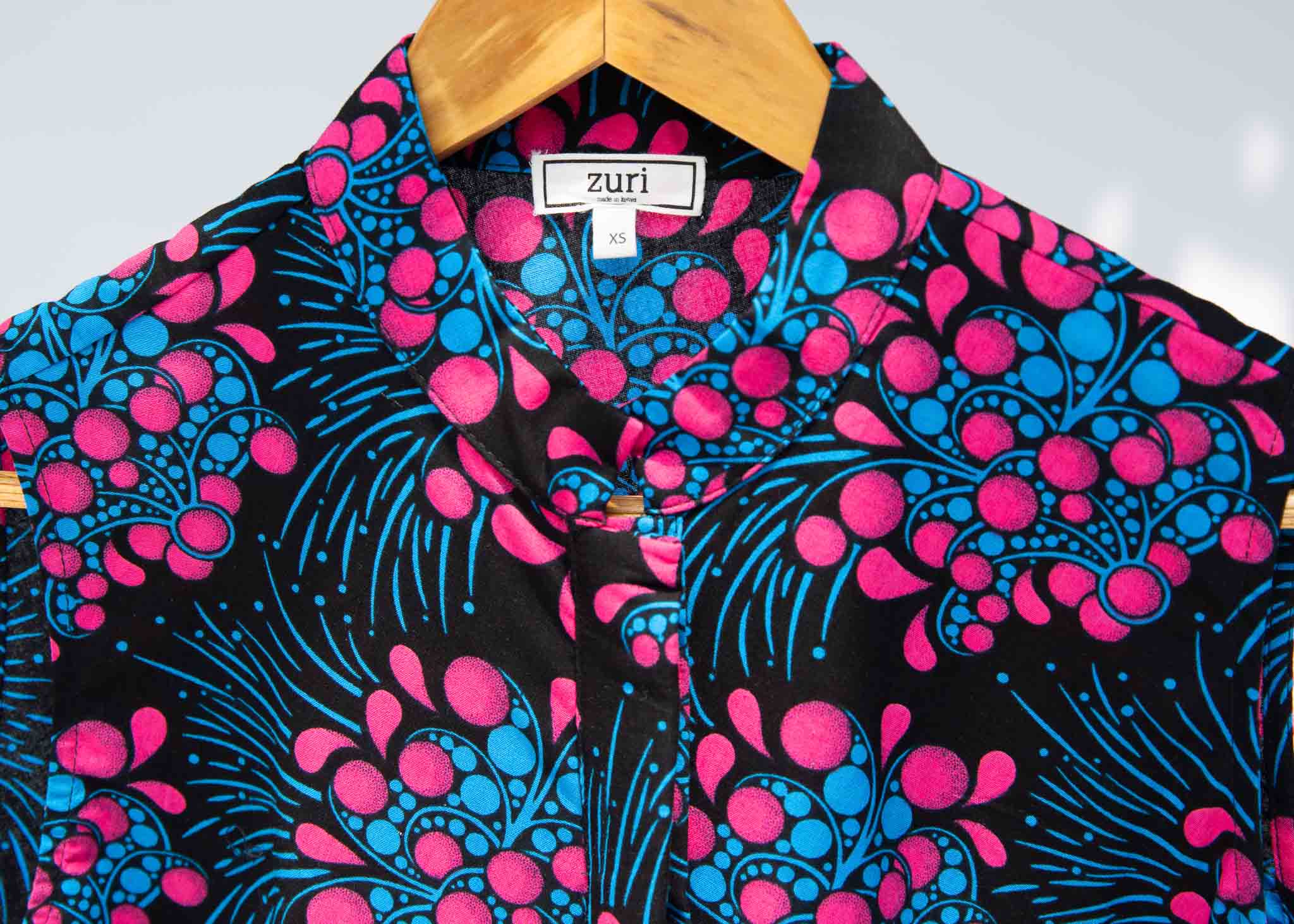 Display of black sleeveless dress with blue and pink poppy print.