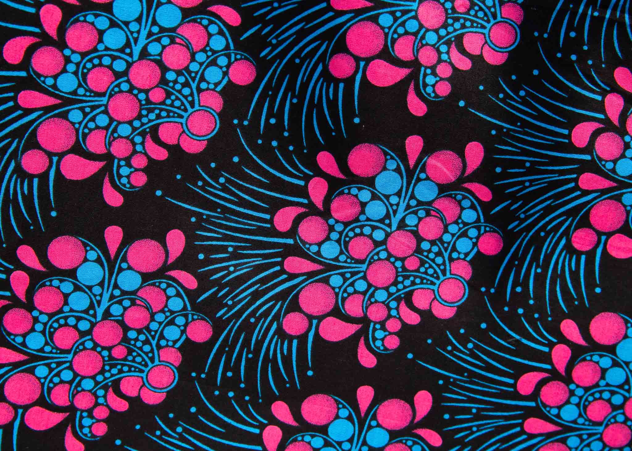Display of black sleeveless dress with blue and pink poppy print.
