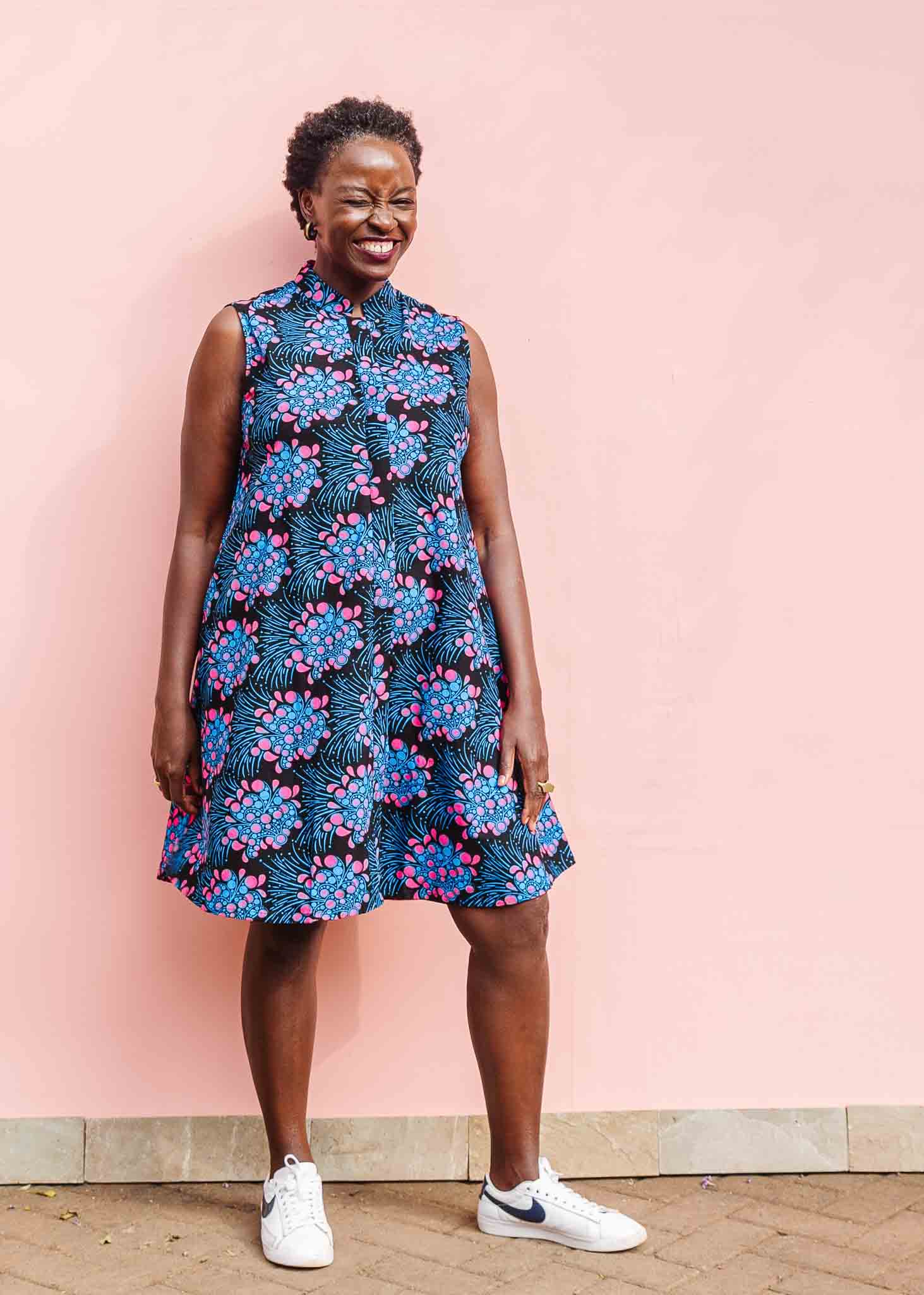 Model wearing black sleeveless dress with blue and pink poppy print.