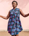 Model wearing black sleeveless dress with blue and pink poppy print.