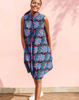 Model wearing black sleeveless dress with blue and pink poppy print.