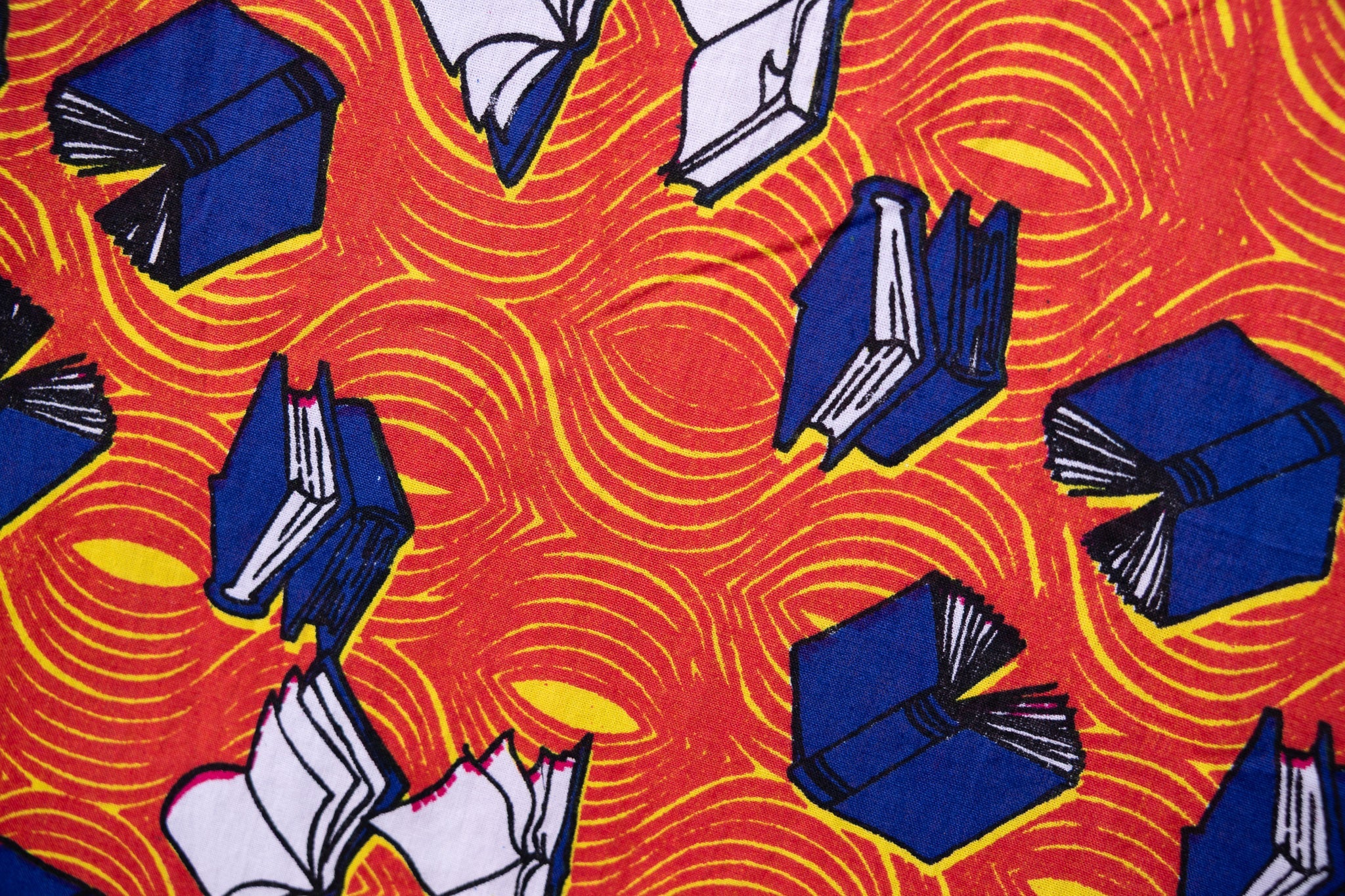 Close up display of yellow and red, blue book print dress.