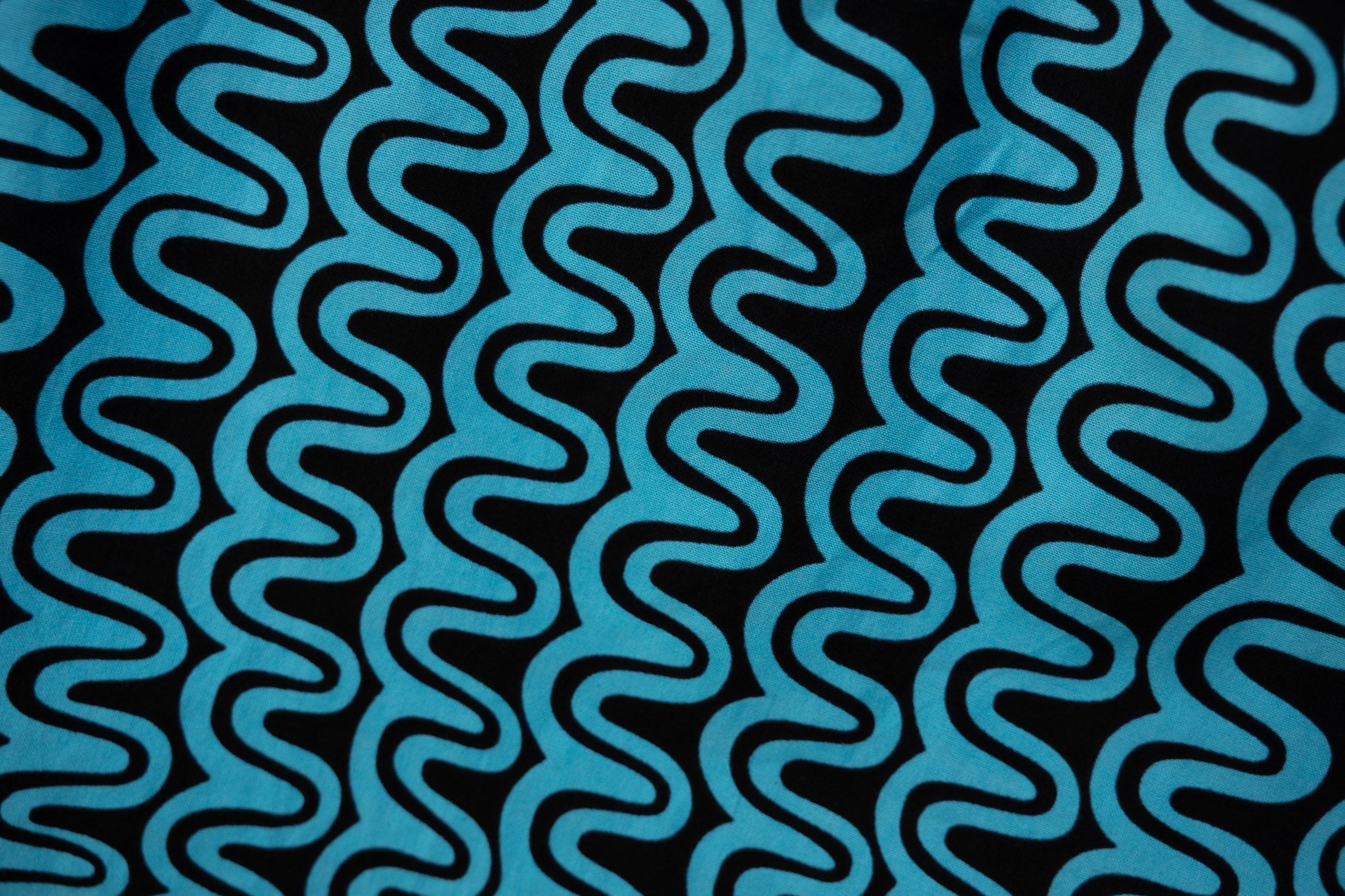 Close up display of blue and black squiggle print dress, fabric.