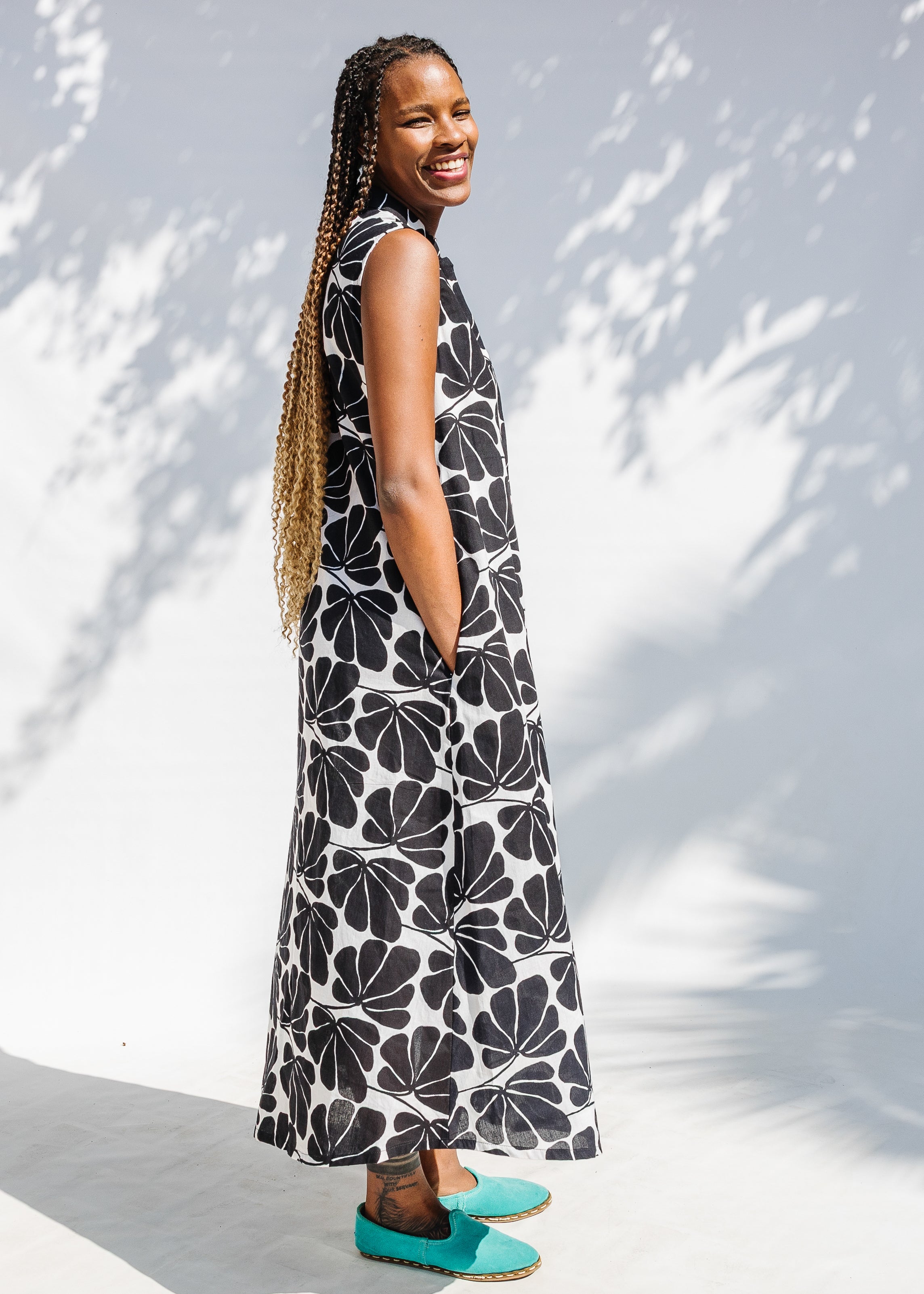 Model wearing black and white floral print, sleeveless dress.