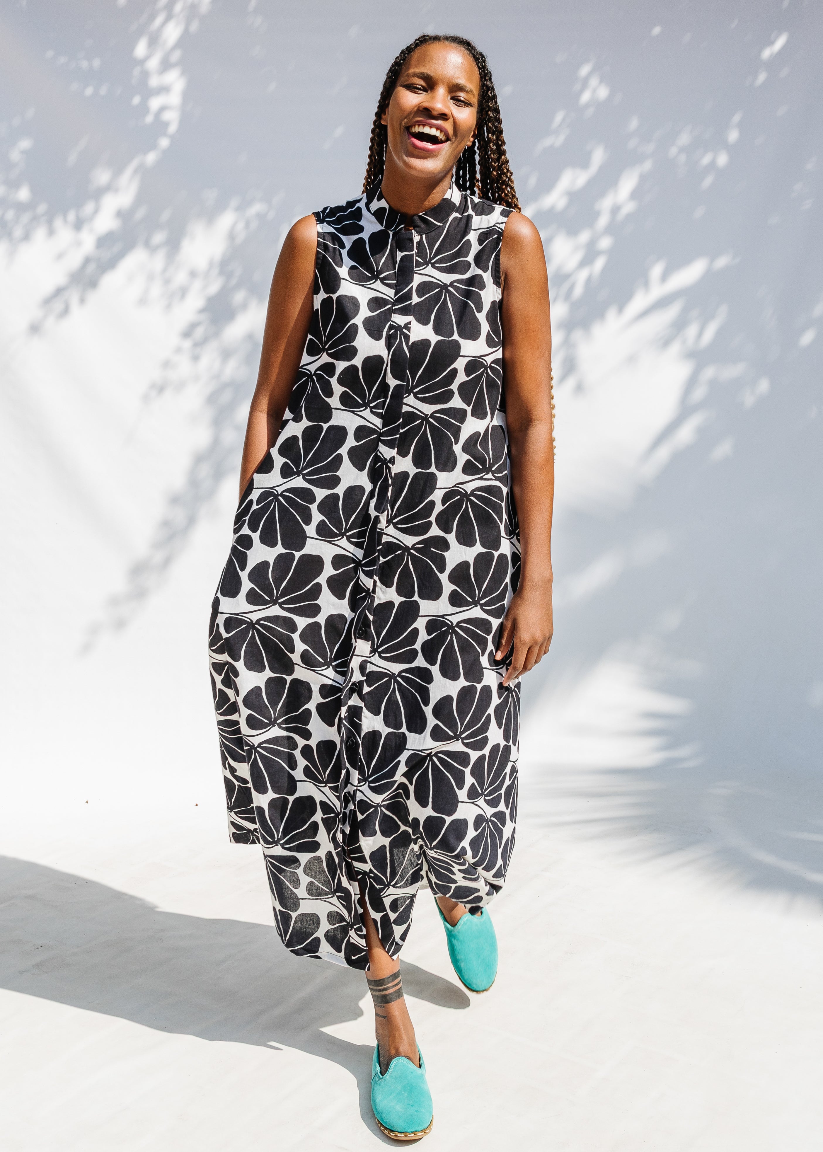 Model wearing black and white floral print, sleeveless dress.