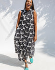 Model wearing black and white floral print, sleeveless dress.