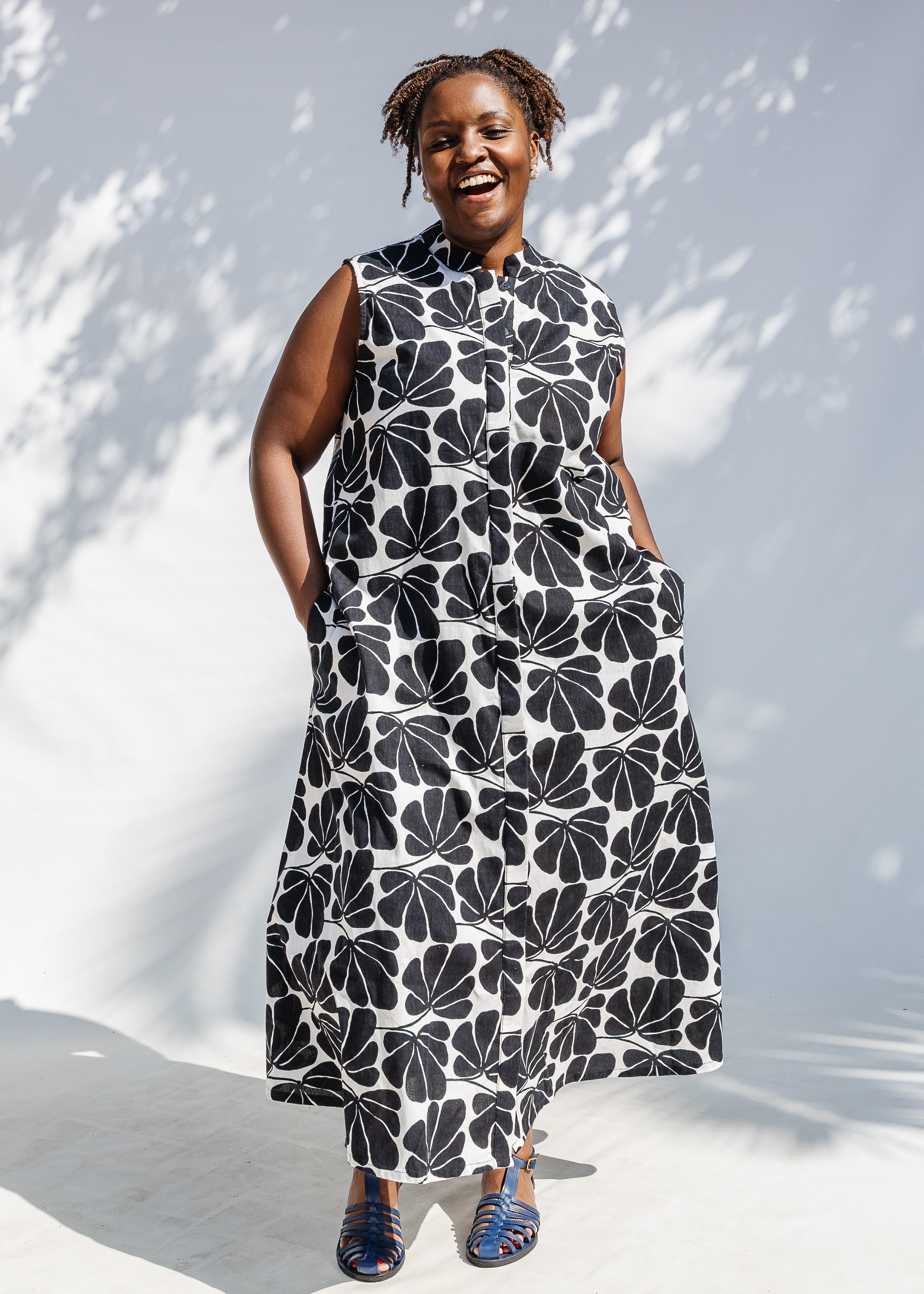 Model wearing black and white floral print, sleeveless dress.