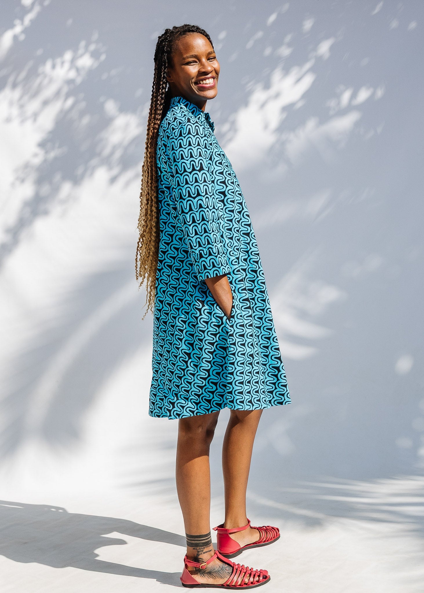 Model wearing blue and black squiggle print dress.