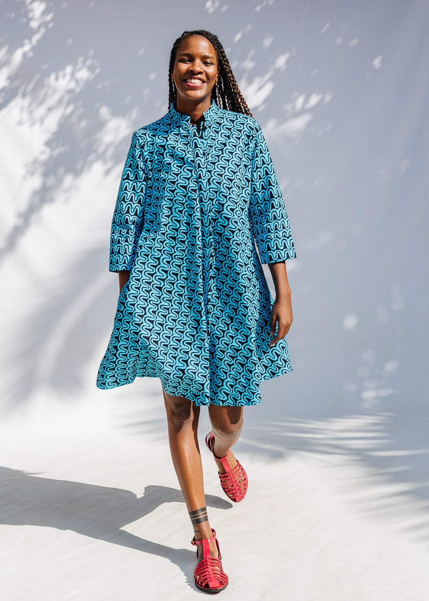 Model wearing blue and black squiggle print dress.