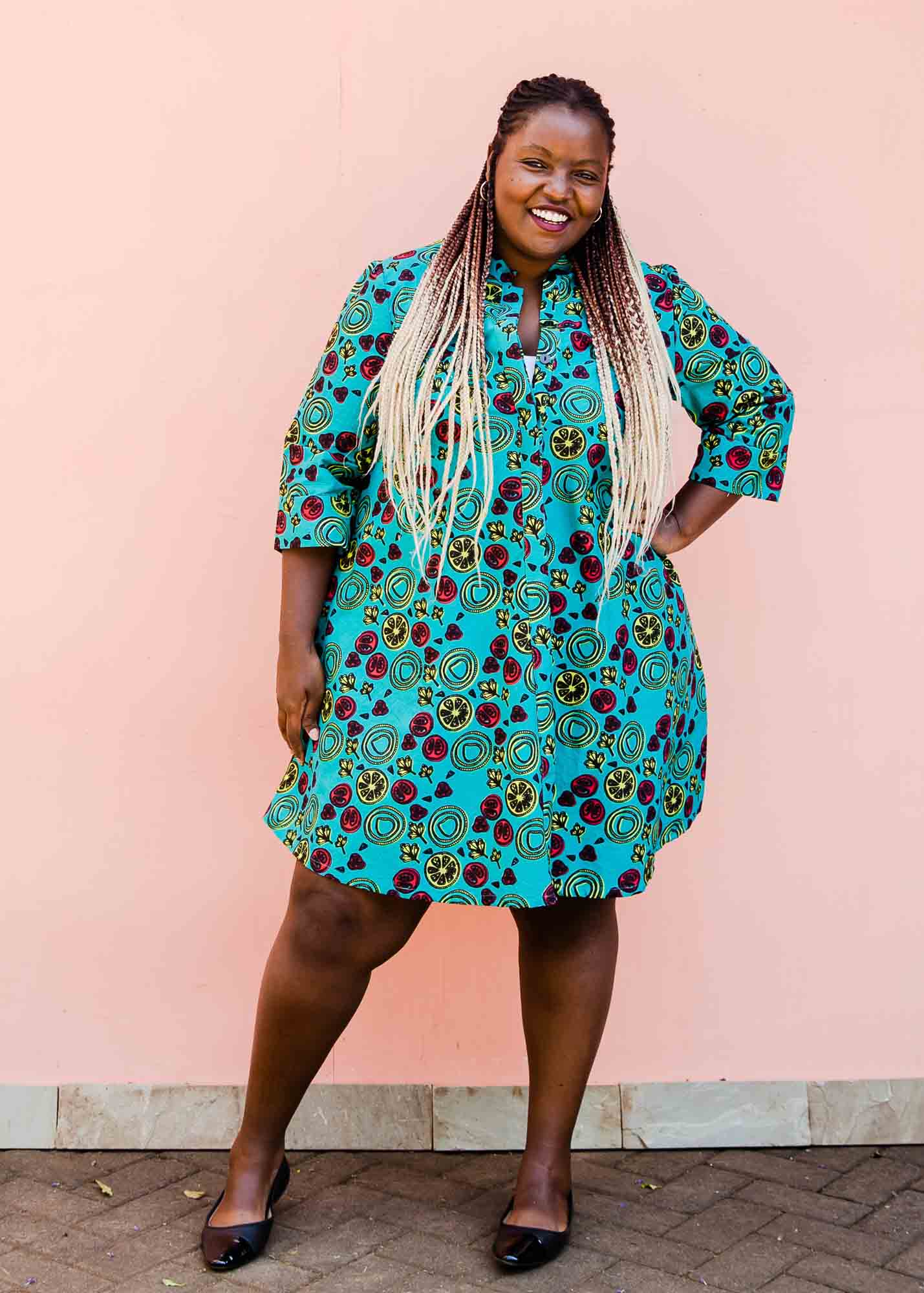 model wearing a green, red and yellow vegetable design dress