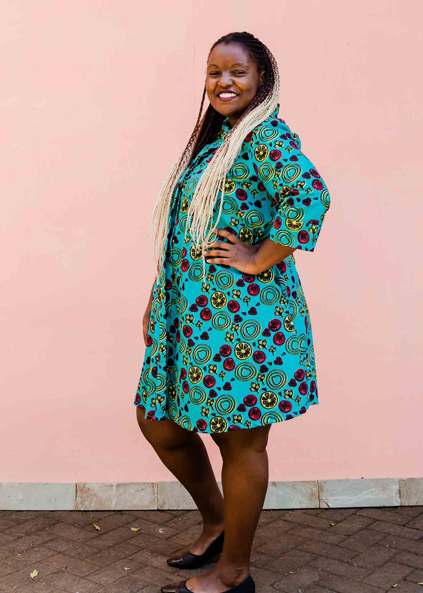 model wearing a green, red and yellow vegetable design dress