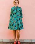 model wearing a green, red and yellow vegetable design dress