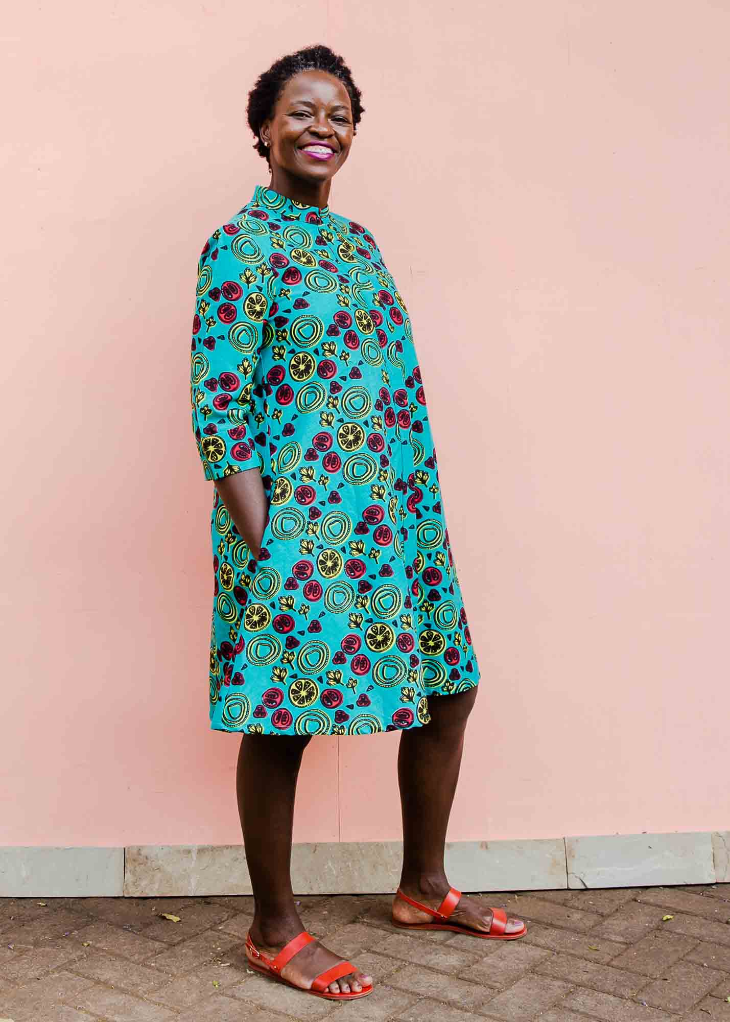 model wearing a green, red and yellow vegetable design dress