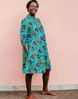 model wearing a green, red and yellow vegetable design dress