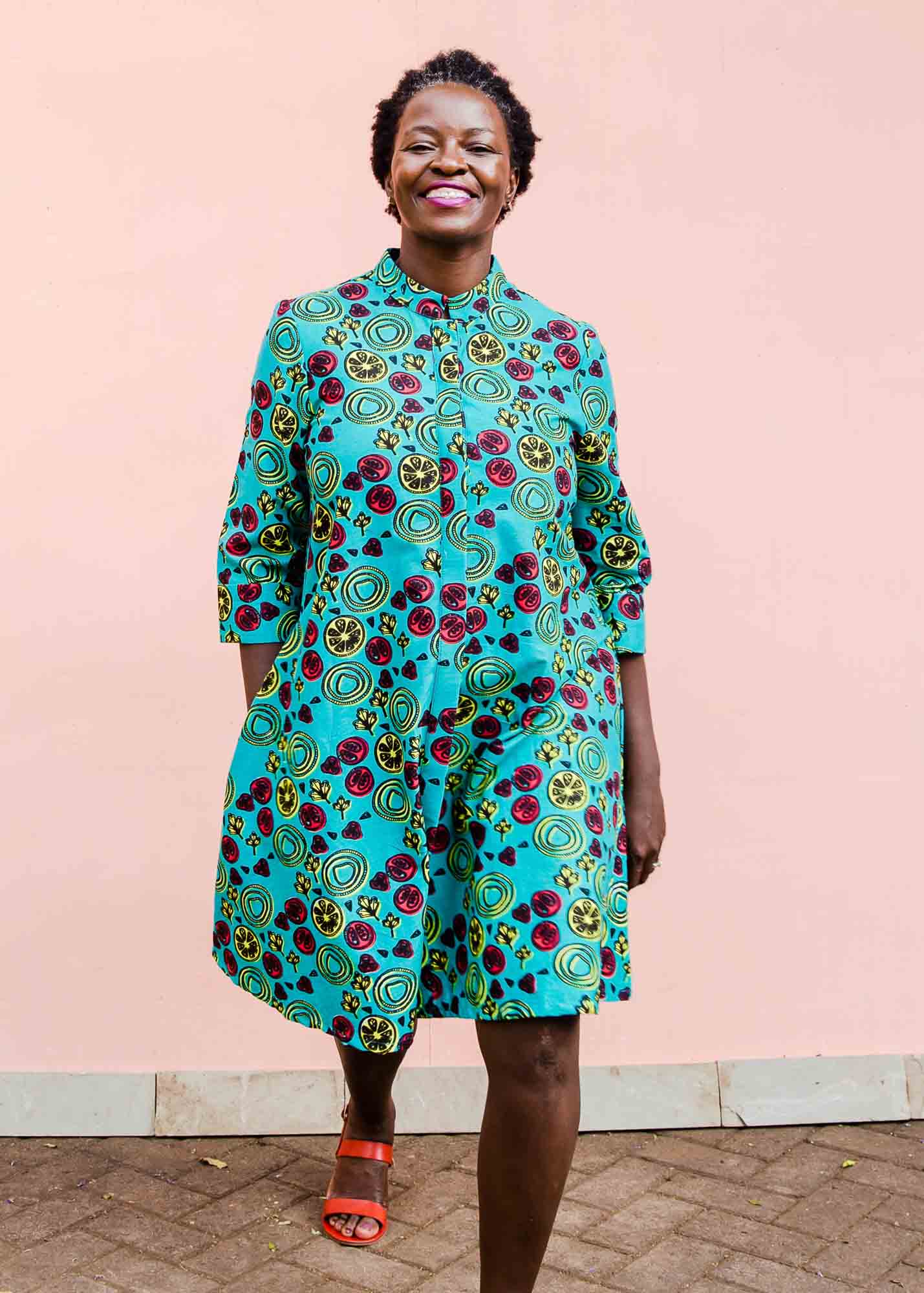 model wearing a green, red and yellow vegetable design dress