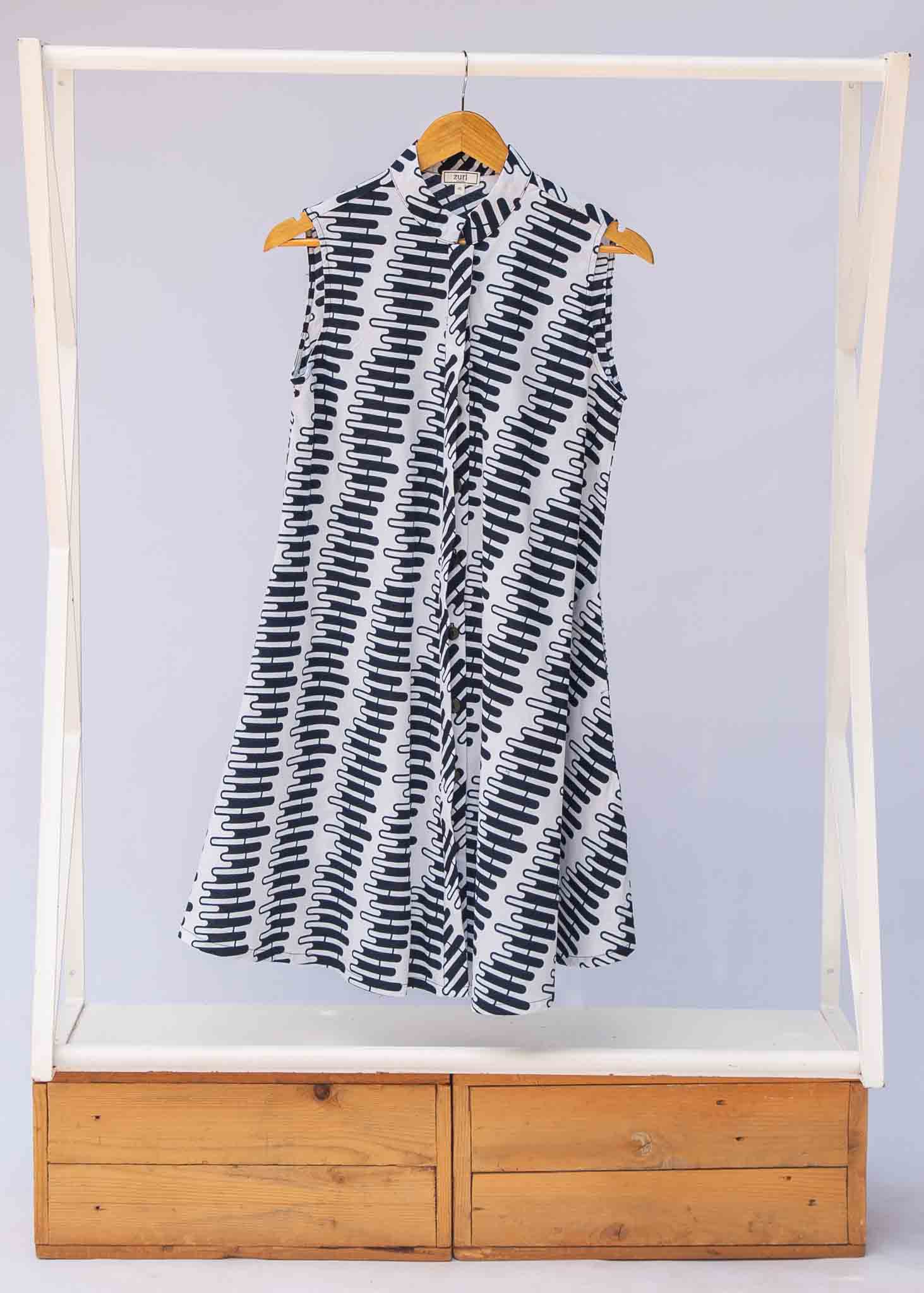 Display of white sleeveless dress with black and white zigzag print.