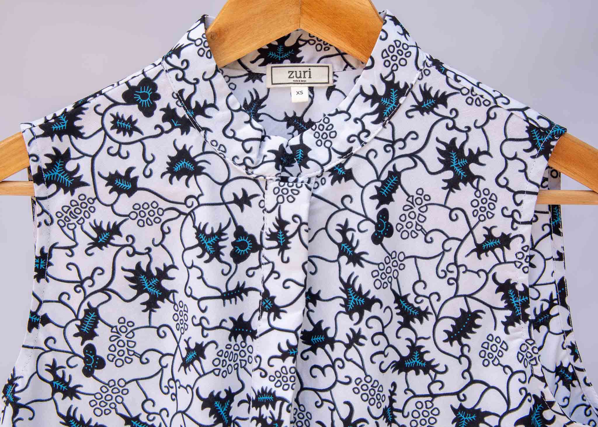 Display of white sleeveless dress with blue floral print.