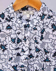 Display of white sleeveless dress with blue floral print.