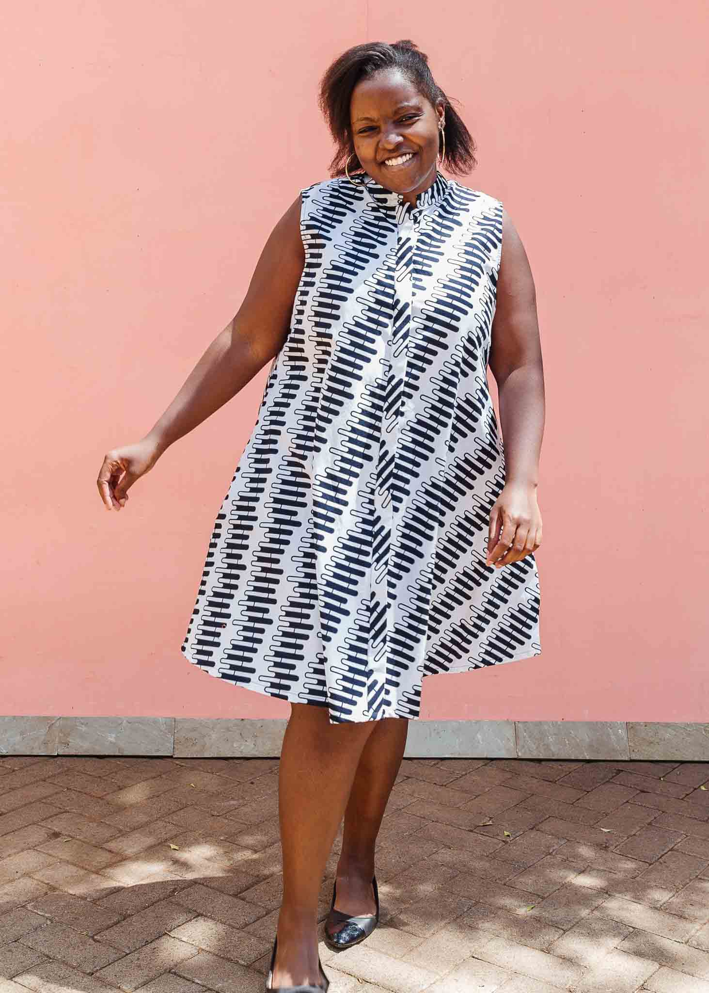 Model wearing white sleevless dress with black and white zigzag print.