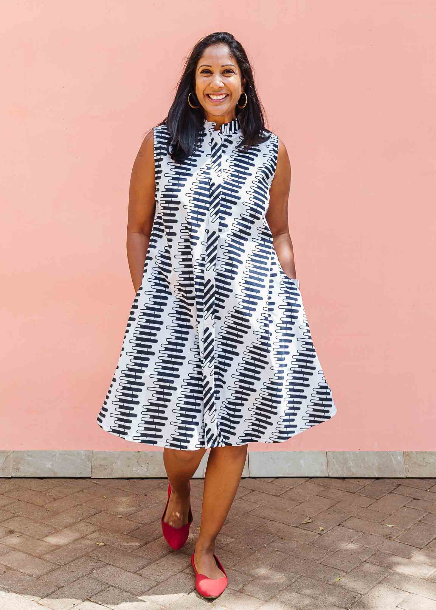 Model wearing white sleevless dress with black and white zigzag print.