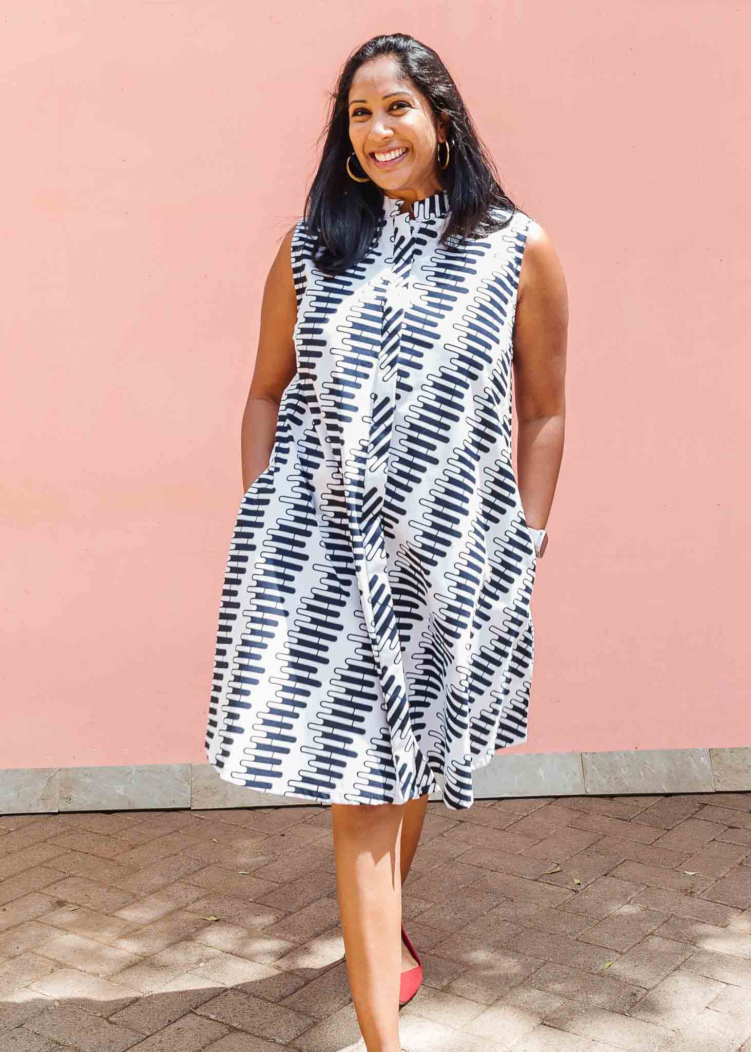 Model wearing white sleevless dress with black and white zigzag print.