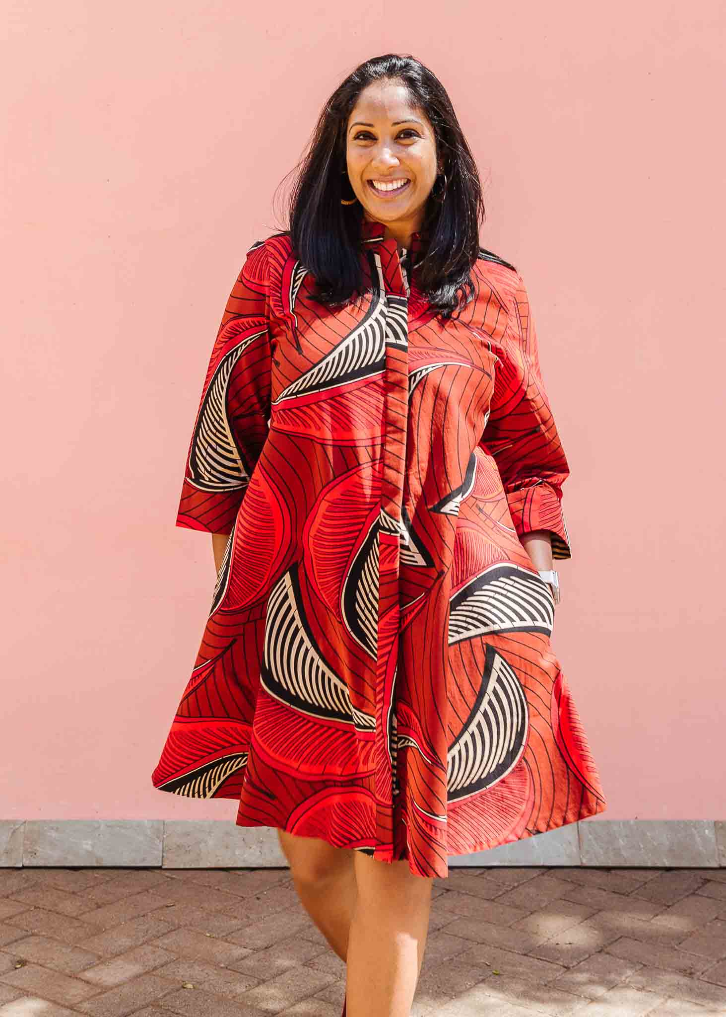 Model wearing red shaded, large feather print dress.