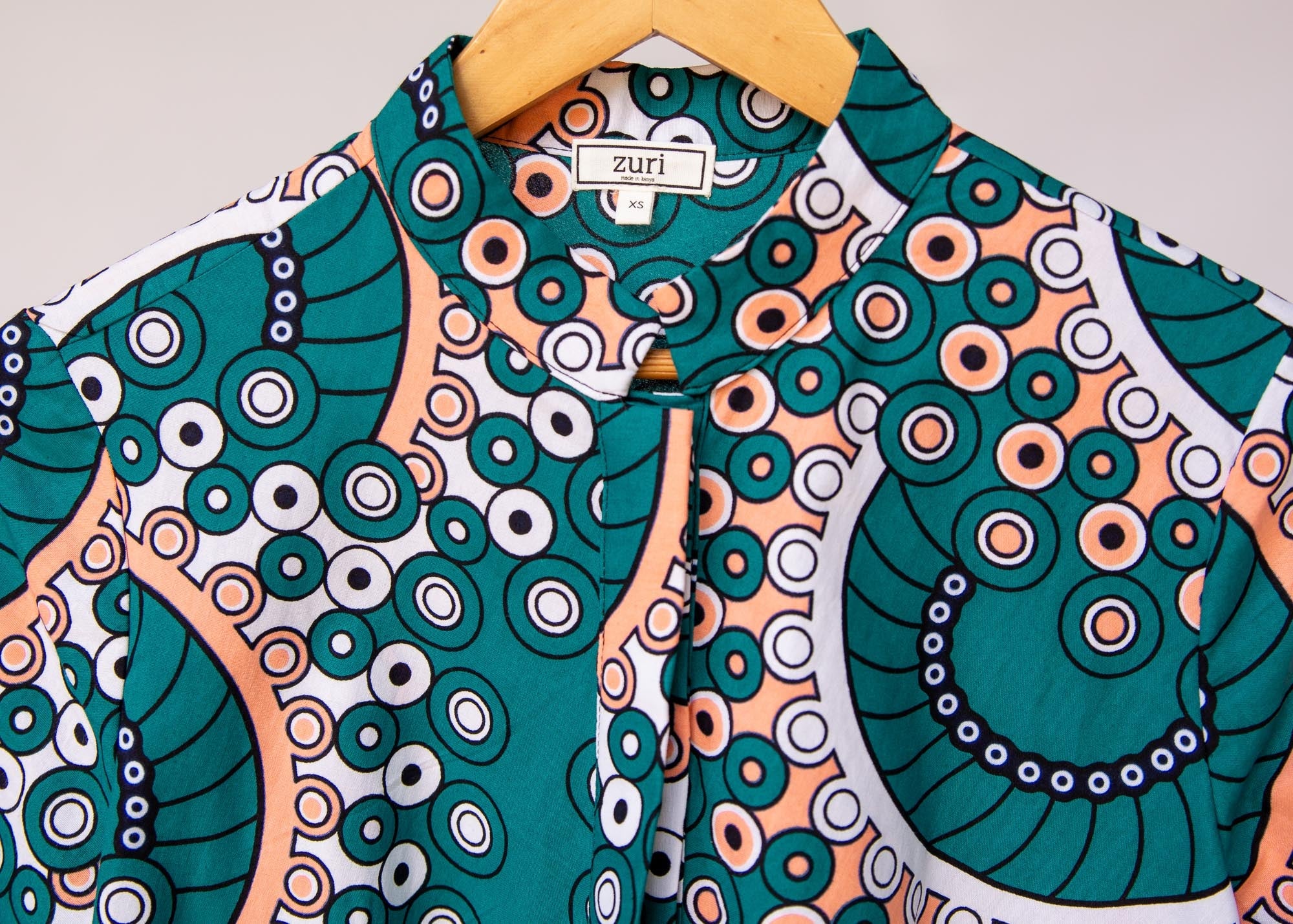 Display of teal, white, black and peach dress with gears
