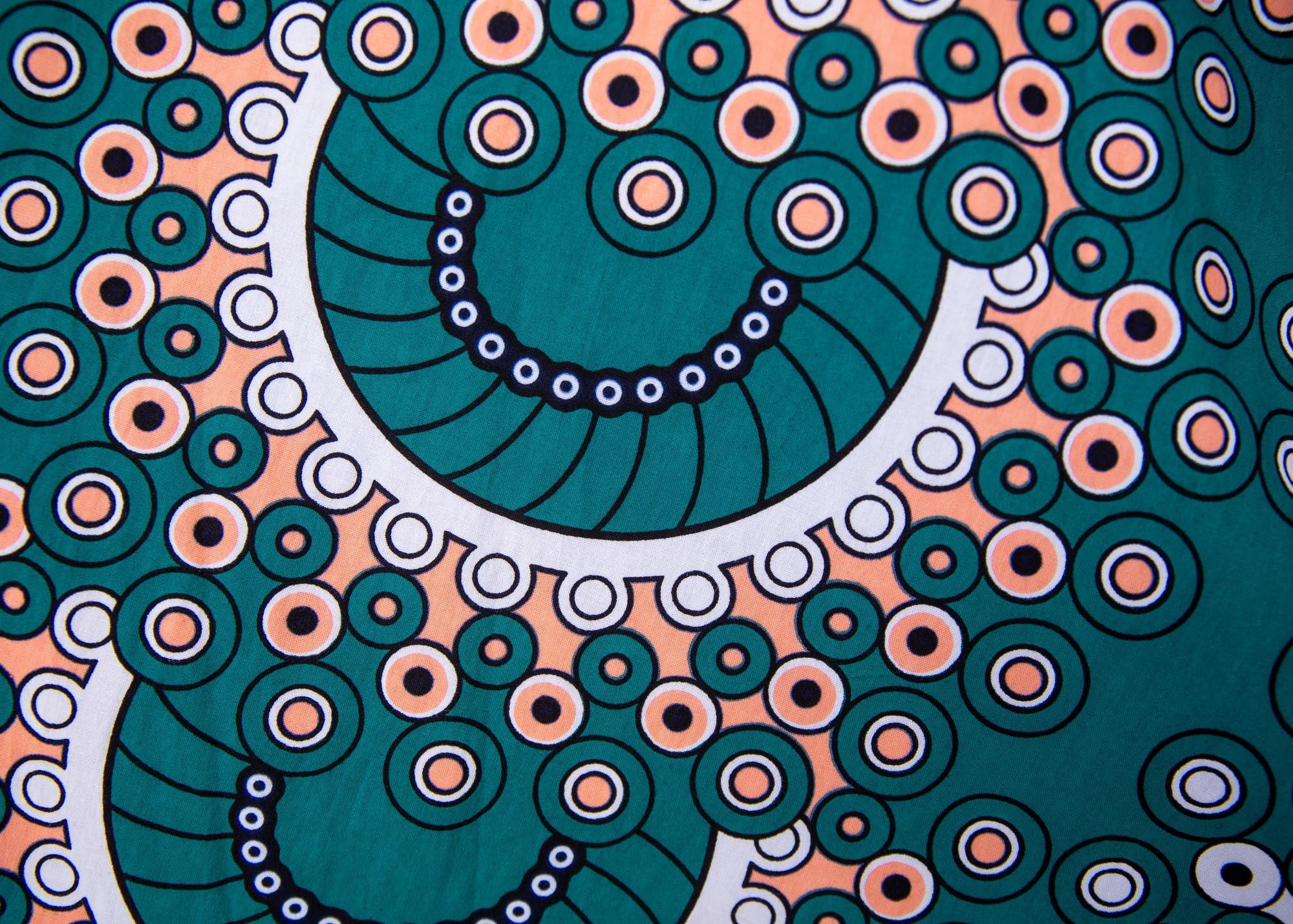 Close up display of teal, white, black and peach dress with gears