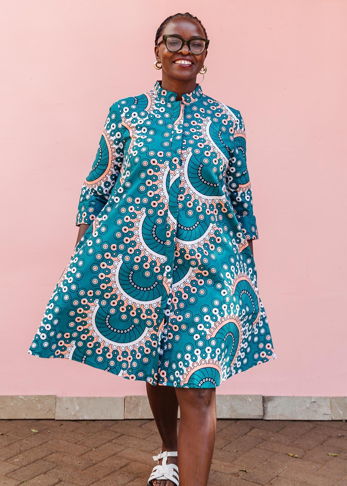 The model is wearing teal, white, black and peach dress with gears