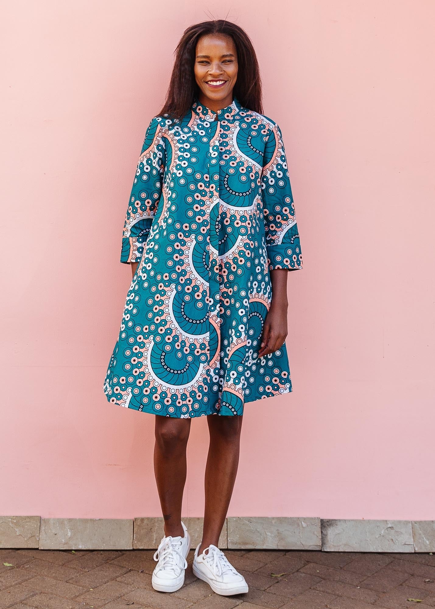 The model is wearing teal, white, black and peach dress with gears