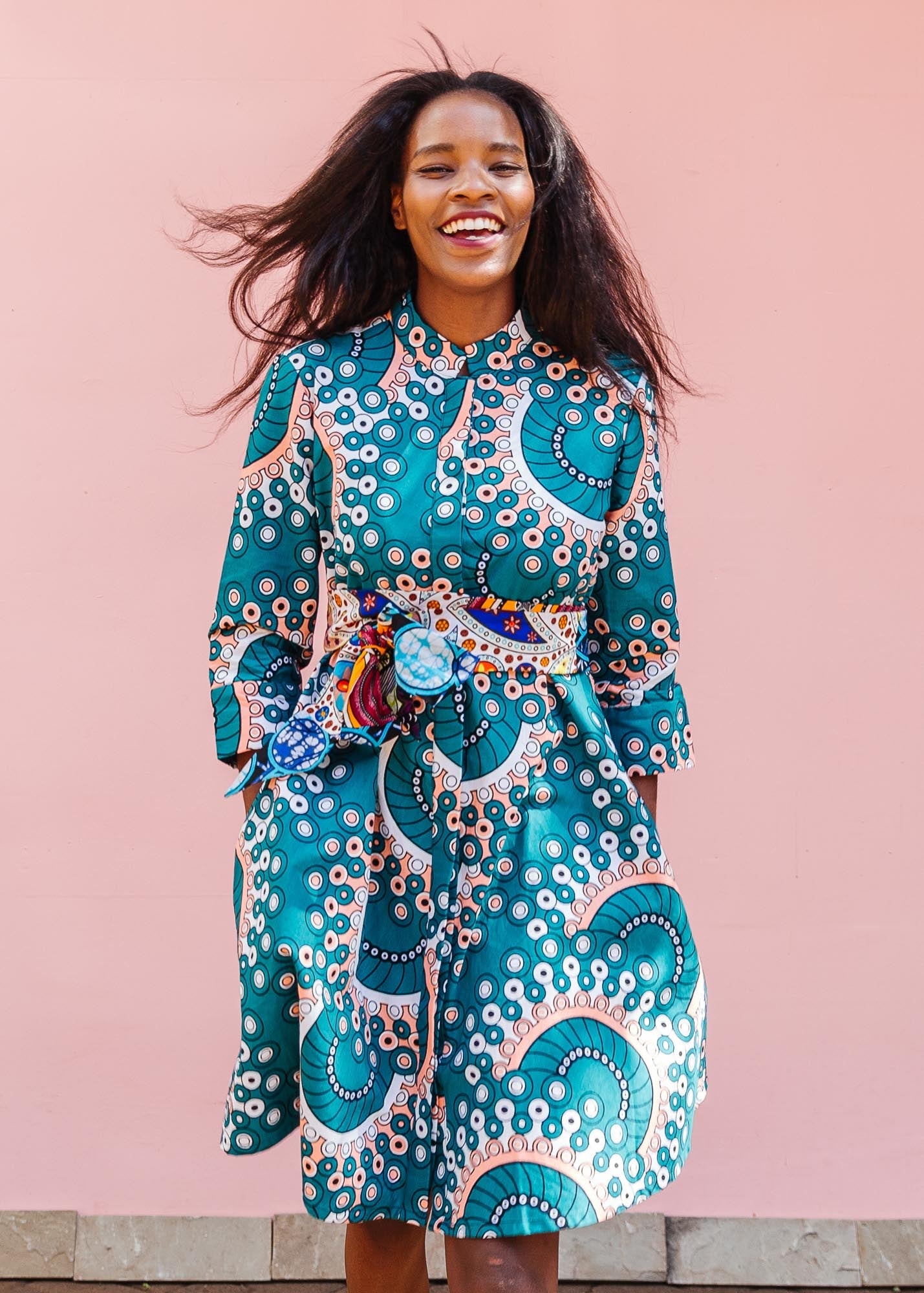 The model is wearing teal, white, black and peach dress with gears