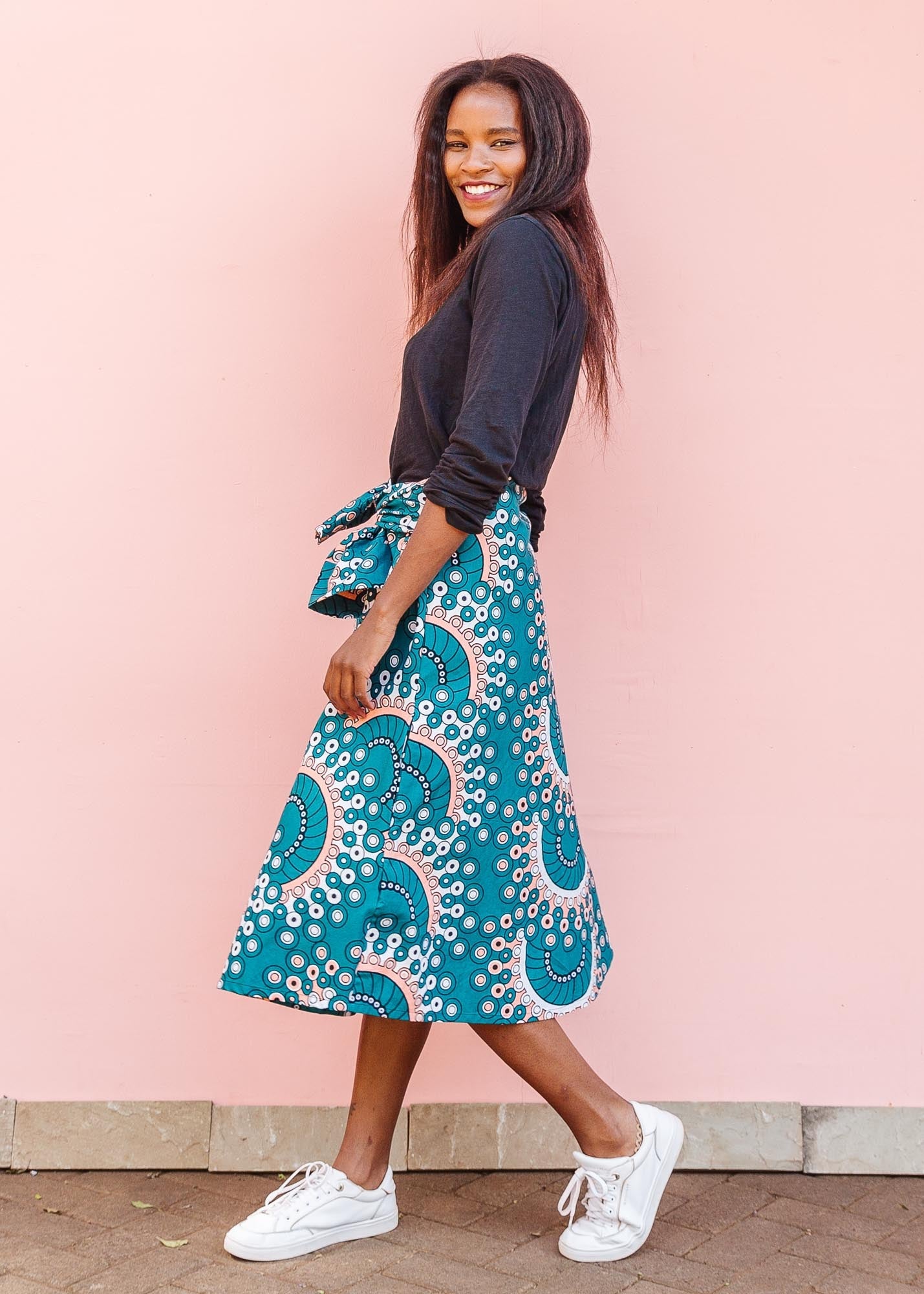 The model is wearing teal, white, black and peach dress with gears