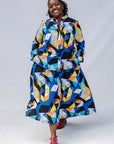 Model wearing blue, black, orange, yellow and white geometric print shirt and pant set.