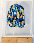 Display of blue, black, orange, yellow and white geometric print shirt.