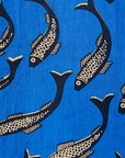 Close up display of blue dress with beige fish print, fabric.