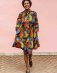 Model wearing black dress with rainbow brushstroke print.