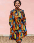Model wearing black dress with rainbow brushstroke print.