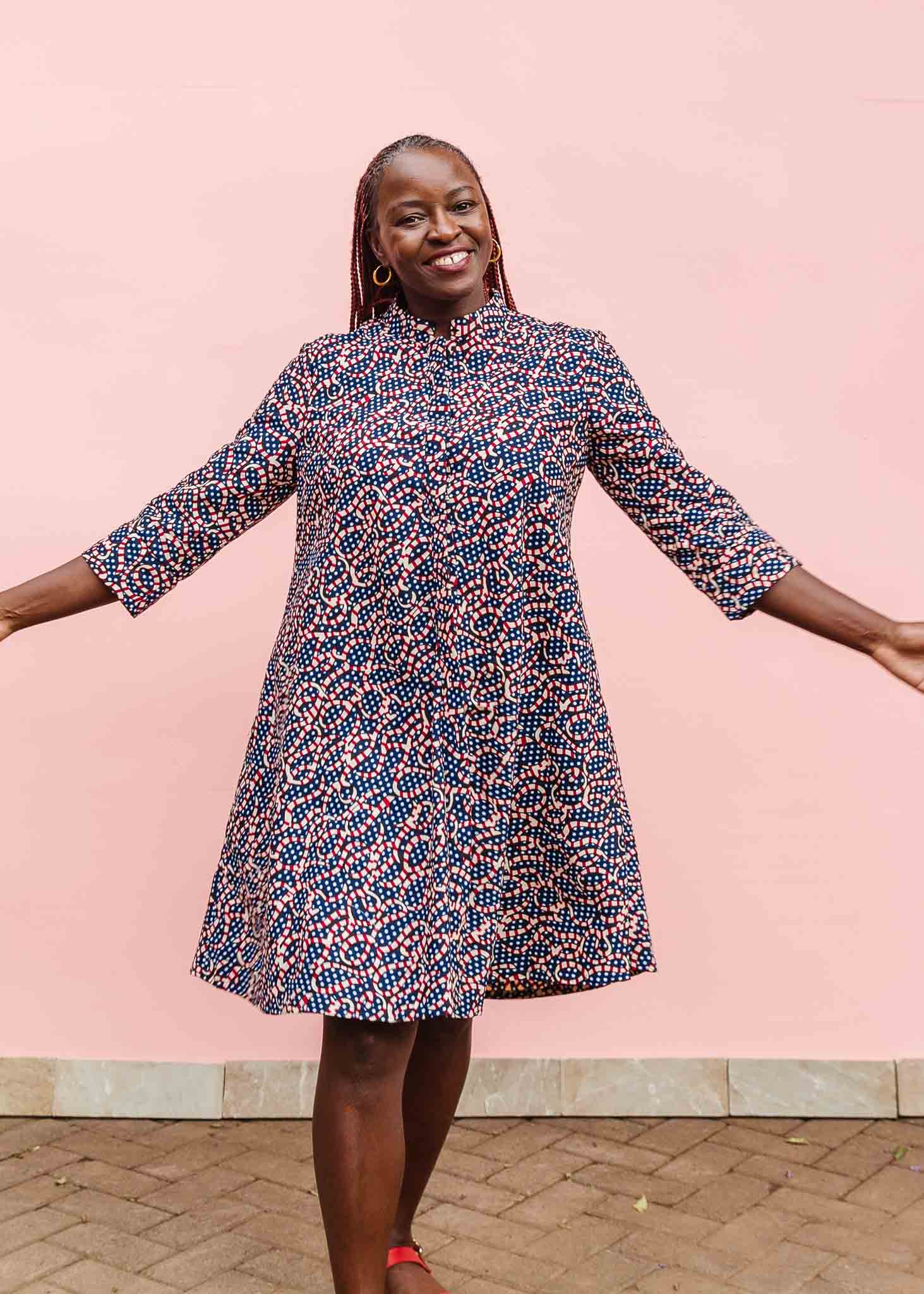 Model wearing blue and red ribbon print dress.